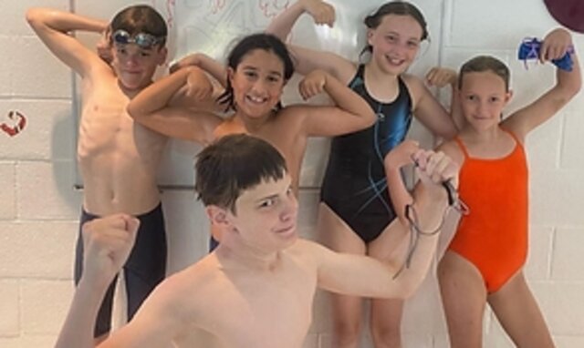 Group of Boundary Bay Bluebacks swimmers in team hoodies at a summer meet